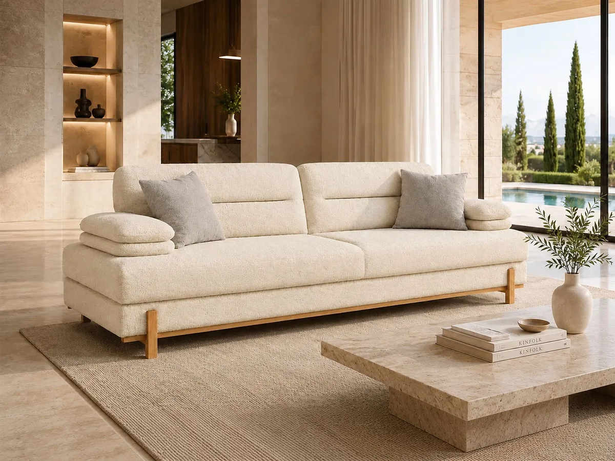 Side view of the SIMENA sofa with slim dark legs, upholstered base and modern curved form.